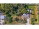 An aerial view of a quaint home surrounded by lush trees, a driveway, and an additional carport at 5150 Old Howell Branch Rd, Winter Park, FL 32792