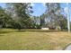 Spacious front yard featuring mature trees and lush greenery, with the house in the background at 5150 Old Howell Branch Rd, Winter Park, FL 32792