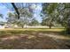 A view of a large front yard featuring well-maintained grass, shade trees, and a street in the background at 5150 Old Howell Branch Rd, Winter Park, FL 32792