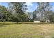 Spacious front yard with mature trees and lush greenery, with a view of the front of the house at 5150 Old Howell Branch Rd, Winter Park, FL 32792