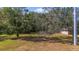 Wide expanse of green lawn and mature trees providing shade and a peek at the house at 5150 Old Howell Branch Rd, Winter Park, FL 32792