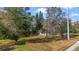 Spacious front yard with mature trees, lush grass, and a glimpse of the home at 5150 Old Howell Branch Rd, Winter Park, FL 32792