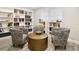 Cozy library nook with comfortable chairs, a central table, and built-in bookshelves at 5150 Old Howell Branch Rd, Winter Park, FL 32792