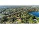 Expansive aerial view of neighborhood with mature trees and a glimpse of a serene lake at 5203 Pineview Way, Apopka, FL 32703