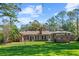 A well-maintained home showcasing a lush green lawn, quaint gazebo, and full brick exterior at 5203 Pineview Way, Apopka, FL 32703
