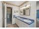 Bright bathroom featuring double sinks, a blue countertop, and decorative wallpaper border at 5203 Pineview Way, Apopka, FL 32703