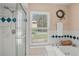 Bright bathroom featuring a jetted tub, shower with glass door, and large window at 5203 Pineview Way, Apopka, FL 32703