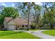Charming single-story home with well-manicured lawn and a paved driveway, surrounded by mature trees at 5203 Pineview Way, Apopka, FL 32703