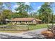 Traditional brick home with a well-kept lawn, wooden fence, and paved driveway at 5203 Pineview Way, Apopka, FL 32703