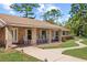 Inviting front porch has rocking chairs with a brick facade, walkway, and manicured landscaping at 5203 Pineview Way, Apopka, FL 32703