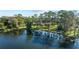 Scenic view of the tranquil lake with mature trees, lush green lawns and brick home in the background at 5203 Pineview Way, Apopka, FL 32703