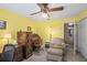 Bright home office featuring a wooden roll top desk and a comfortable seating area at 5203 Pineview Way, Apopka, FL 32703