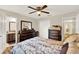 Inviting bedroom boasts wood flooring, ceiling fan, and views into the bathroom at 5715 Satel Dr, Orlando, FL 32810