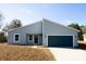 Charming single-story home featuring a blue garage door, modern design, and well-maintained front yard at 656 Marion Oaks Mnr, Ocala, FL 34473