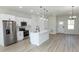 Modern kitchen featuring stainless appliances, white cabinetry, quartz countertops, and a functional island at 656 Marion Oaks Mnr, Ocala, FL 34473