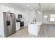 Well-lit kitchen features a stainless steel refrigerator, modern appliances, white cabinetry, and center island at 656 Marion Oaks Mnr, Ocala, FL 34473