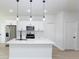 Modern kitchen with white cabinets, stainless steel appliances, and a center island with pendant lighting at 656 Marion Oaks Mnr, Ocala, FL 34473