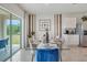 Bright and airy dining room with a glass table, stylish seating, and natural light from a sliding glass door to the backyard at 7077 Painted Bunting Way, St Cloud, FL 34773
