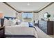 The main bedroom offers an inviting bedroom with a comfortable bed, dresser, bedside table and lots of natural light at 7077 Painted Bunting Way, St Cloud, FL 34773