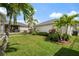 Lush backyard featuring tropical landscaping and manicured lawn with a view of neighboring houses at 8852 Sperry St, Orlando, FL 32827