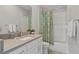 Well-lit bathroom with a combination shower and tub, vanity, and green patterned shower curtain at 8852 Sperry St, Orlando, FL 32827