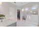 Bright bathroom featuring marble tile, a glass-enclosed shower, a walk-in closet, and white countertops at 8852 Sperry St, Orlando, FL 32827