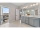 Spacious bathroom with double vanity, grey cabinetry, a large mirror, and a balcony with french doors at 8852 Sperry St, Orlando, FL 32827