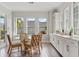 Dining area boasts lots of light with a glass top table, light hard wood flooring, and white cabinetry at 8852 Sperry St, Orlando, FL 32827
