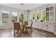 Bright dining area featuring hardwood floors, large windows, a glass top table, and white cabinets at 8852 Sperry St, Orlando, FL 32827