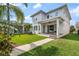 Back exterior view of a beautifully landscaped home with a covered porch and manicured lawn at 8852 Sperry St, Orlando, FL 32827