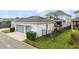 View of a two-car garage, manicured lawn, and fenced yard, surrounded by a well-maintained community at 8852 Sperry St, Orlando, FL 32827