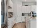 Modern kitchen boasts white cabinetry, stainless steel appliances, sleek countertops, and hardwood floors at 8852 Sperry St, Orlando, FL 32827