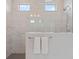 Shower with marble tile, dual shower heads, built-in lighting, glass enclosure and two small windows at 8852 Sperry St, Orlando, FL 32827