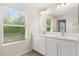 Bright bathroom featuring double sink vanity with shaker cabinets, framed mirror and natural light at 10608 Savannah Plantation Ct, Orlando, FL 32832