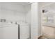 Convenient laundry room featuring washer, dryer, wire rack shelving and access to the bedroom at 10608 Savannah Plantation Ct, Orlando, FL 32832