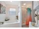 This serene bathroom features a soaking tub and a separate shower with colorful curtain at 130 Bloomingdale Dr, Davenport, FL 33897