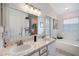 Bright bathroom features double sinks, stylish vanity, and a soaking tub for a relaxing retreat at 130 Bloomingdale Dr, Davenport, FL 33897