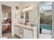 Bathroom vanity with double sinks and a view to a private screened-in pool at 130 Bloomingdale Dr, Davenport, FL 33897