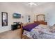 Cozy bedroom boasts a ceiling fan, TV, and a warm ambiance with a decorative fireplace at 130 Bloomingdale Dr, Davenport, FL 33897