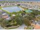 Scenic aerial shot of a community lake featuring a fountain, beach, tennis courts, and lush green spaces at 130 Bloomingdale Dr, Davenport, FL 33897