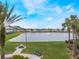 Picturesque view of a tranquil community lake with a fountain, benches, and palm trees along the shoreline at 130 Bloomingdale Dr, Davenport, FL 33897