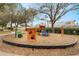 Colorful playground equipment in a community park featuring slides, climbing structures, and a wood chip safety surface at 130 Bloomingdale Dr, Davenport, FL 33897