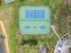Overhead shot of a tennis and basketball court area next to a sandy lakefront at 130 Bloomingdale Dr, Davenport, FL 33897