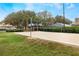 Well-maintained sand volleyball court with a net, surrounded by green grass and various trees at 130 Bloomingdale Dr, Davenport, FL 33897