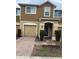 Charming townhome featuring a brick paved drive, attached garage, and a welcoming entryway at 1309 Heritage Commons Dr, Winter Springs, FL 32708