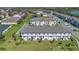 Aerial view of a residential community with townhomes, a pond, and well-kept landscaping at 1620 Pelican Dr, Davenport, FL 33896