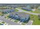 Aerial view of a residential community with townhomes, a pond, and well-kept landscaping at 1620 Pelican Dr, Davenport, FL 33896