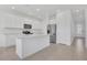 Bright kitchen boasts a large island, stainless steel refrigerator, and sleek white cabinetry at 1620 Pelican Dr, Davenport, FL 33896