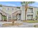 Townhouse exterior with light green siding, wood stairs, and a green lawn with a palm tree at 185 Scottsdale Sq # 185, Winter Park, FL 32792