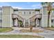 The exterior of the townhome features matching stairways, light green siding, and a front yard at 185 Scottsdale Sq # 185, Winter Park, FL 32792